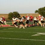 Jacob VanLith (13) hands the ball off to Cole Tjossem (22) and Dante Johnson (67) holds the line.