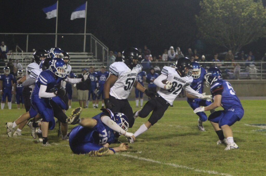 Wolverine Boston Riedemann (#82) carries the ball while trying to get past MMC-RU's defense during Friday night football action against MMC-RU held in Marcus. Photo by Vanessa Rohwer.